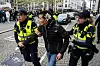 Zwei Polizisten nehmen in Amsterdam einen Mann fest