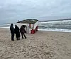 Spaziergänger stehen vor dem Wrack.