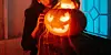 Eine Frau posiert vor einem Halloween-Kürbis (Symbolbild).