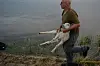 Ein Feuerwehrmann trägt das gerettete Lammböckchen vom Ufer weg.