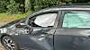 Ein graues Auto mit großen Dellen und ausgelöstem Airbag