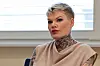 Junge Frau mit kurzen blonden Haaren und tätowiertem Hals