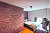 Einige Zimmer befinden sich auf zwei Ebenen und vom Bett aus blickt man auf das Wohnzimmer.
