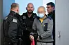 Polizisten halten Angeklagten fest