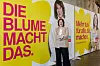 Katarina Blume, Spitzenkandidatin der FDP Hamburg steht vor Kampagnenpostern