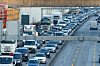 Dichter Verkehr mit Autos und Lastwagen auf der A7 im zähfließenden Autobahnstau.