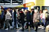 Reisende und Pendler sind im Hauptbahnhof in Hamburg unterwegs, im Hintergrund steht ein Metronom-Zug