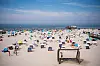 Sankt Peter-Ording: Zahlreiche Touristen sind bei Sonnenschein am Strand an der Nordsee unterwegs.