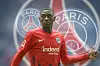 Der Frankfurter Randal Kolo Muani vor mehreren Wappen von Paris Saint-Germain