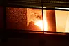 Einsatzkräfte stehen hinter einer Scheibe mit einem Einschussloch an einem Balkon in Stadtteil Altona, nachdem ein Mann mit einer Schusswaffe einen Großeinsatz der Polizei ausgelöst hat.