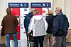Fahrgäste stehen vor einem Fahrkartenautomat.