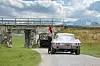 Fräulein Betti“, fotografiert mit einer Chevrolet Corvette C2 Sting Ray. Das Auto steht vor einer Brücke, im Hintergrund sind Berge zu sehen.