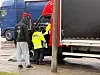 Ein Fahrer wird von Polizisten kontrolliert.