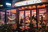 Blick in einen gut gefüllten Imbiss „Kleine Pause“ am Abend, Gäste sitzen dicht gedrängt an Tischen auf St. Pauli (Archivbild).