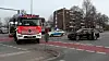 Ein Feuerwehrwagen steht neben einem verunfallten Auto auf einer Kreuzung.