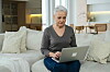 Eine Rentnerin sitzt am Laptop.
