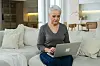 Eine Rentnerin sitzt am Laptop.