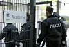 Polizisten gehen durch das Eingangstor der Polizeiakademie.