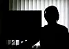 Ein Beamter sitzt mit Kopfhörern vor einem Computer in einem Büro.