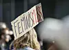 Ein Teilnehmerin einer Demonstration zum Weltfrauentag trägt ein Schild mit der Aufschrift «Feminis-muss».